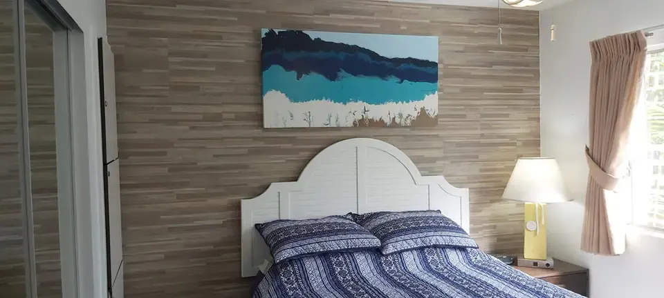 Bedroom with bedside lamps and wall art at Kihei Kai Nani #166