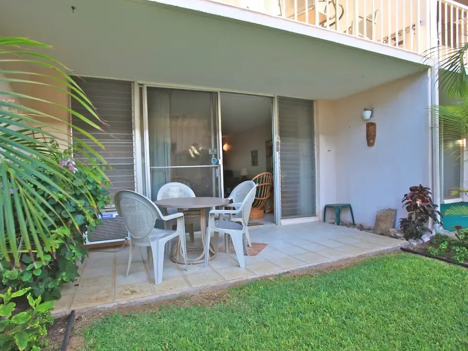 Covered lanai seating beside the garden lawn