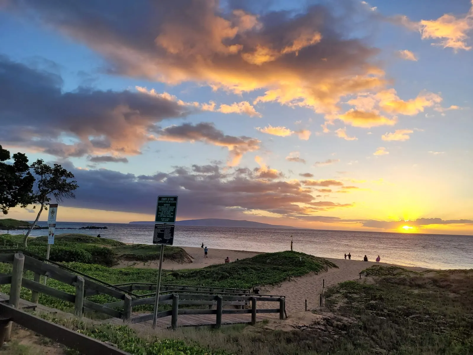 Coastal path and grassy area overlooking the sunset