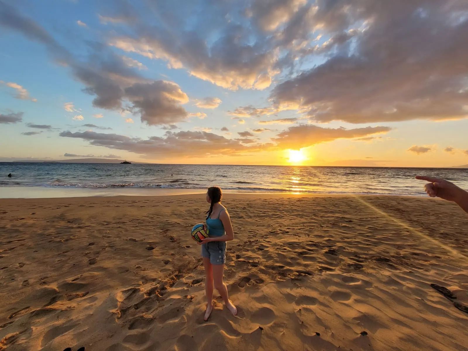 Visitor walking along the sand at sunset